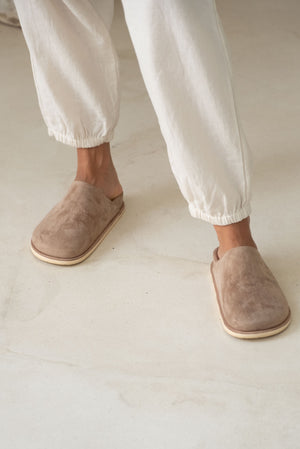 Close-up of soft beige slip-on shoes with sturdy soles.