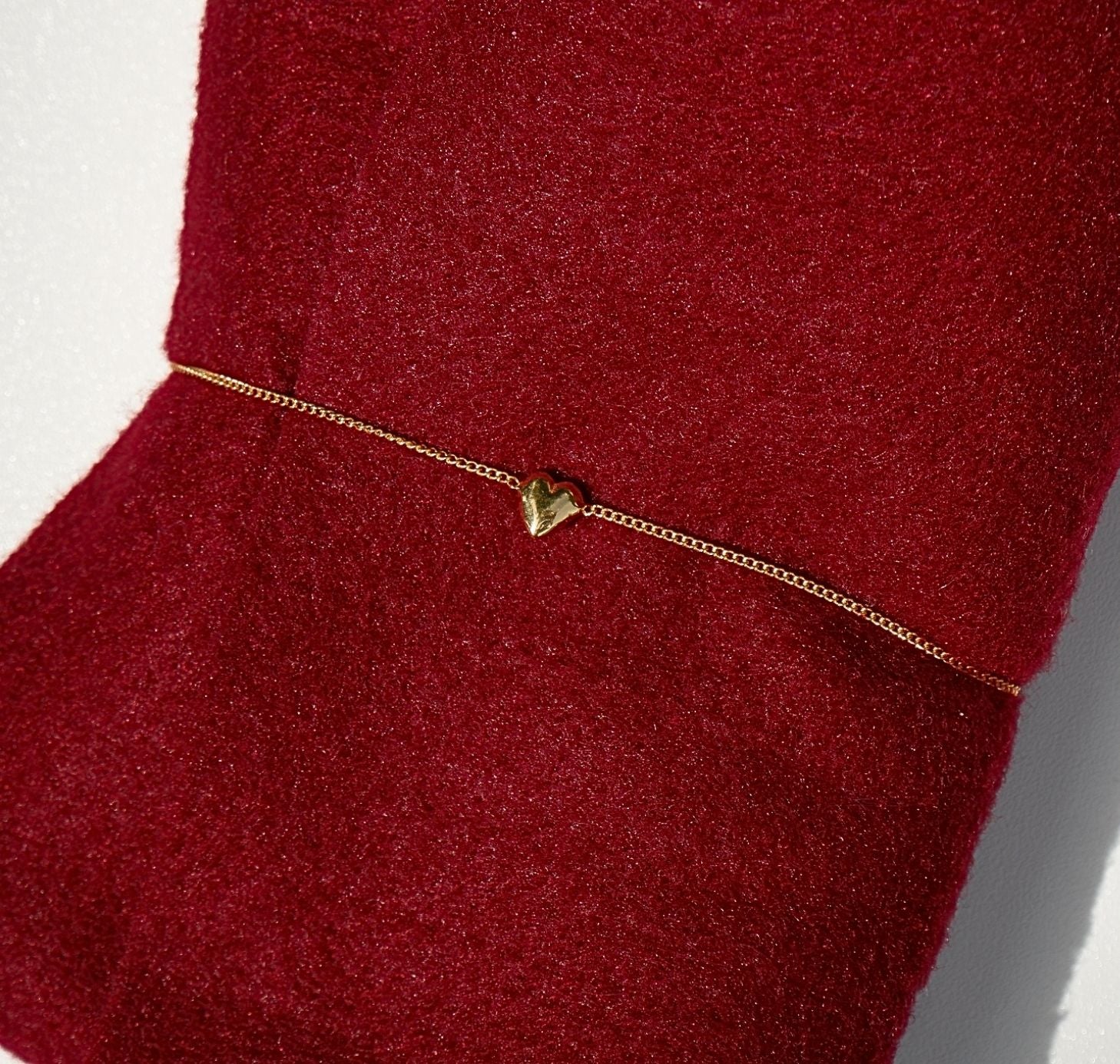 Small heart bracelet on a red piece of fabric