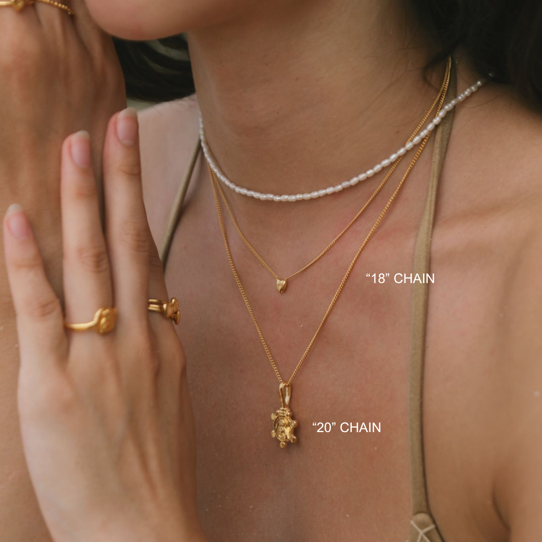 Close-up of a person wearing gold necklaces with chain lengths labeled.