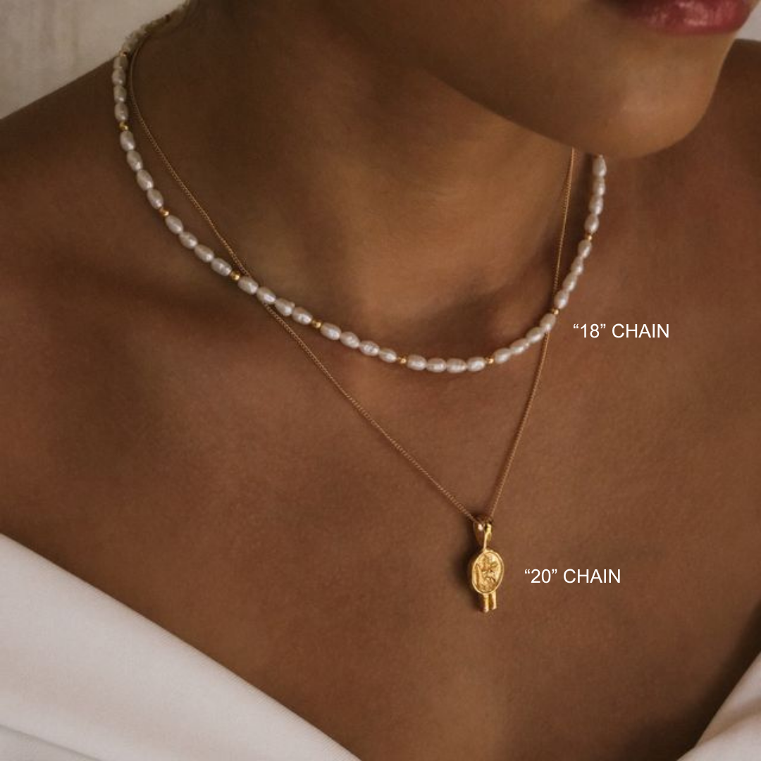 Pearl necklace and gold pendant on a person's neck with chain length labels.