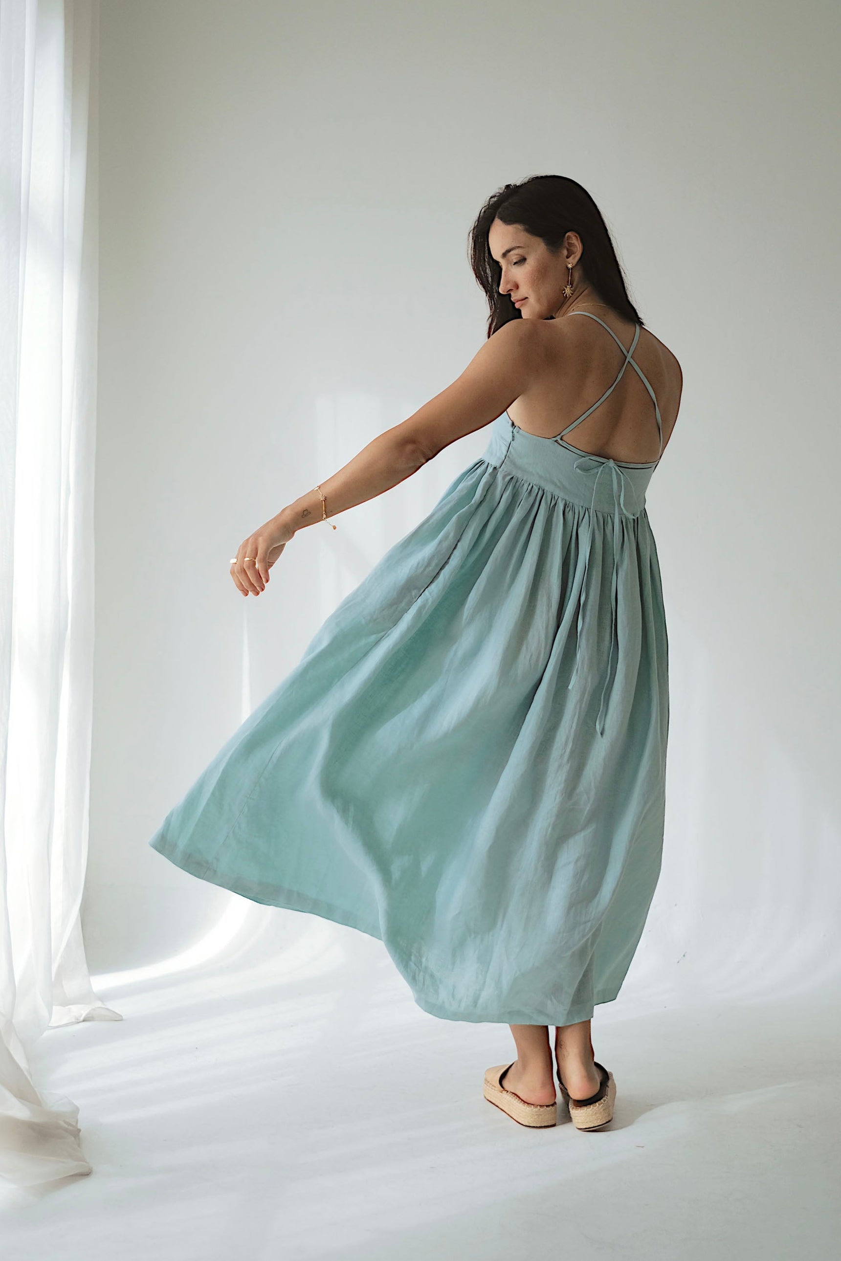 Woman in a light blue dress standing against a white background