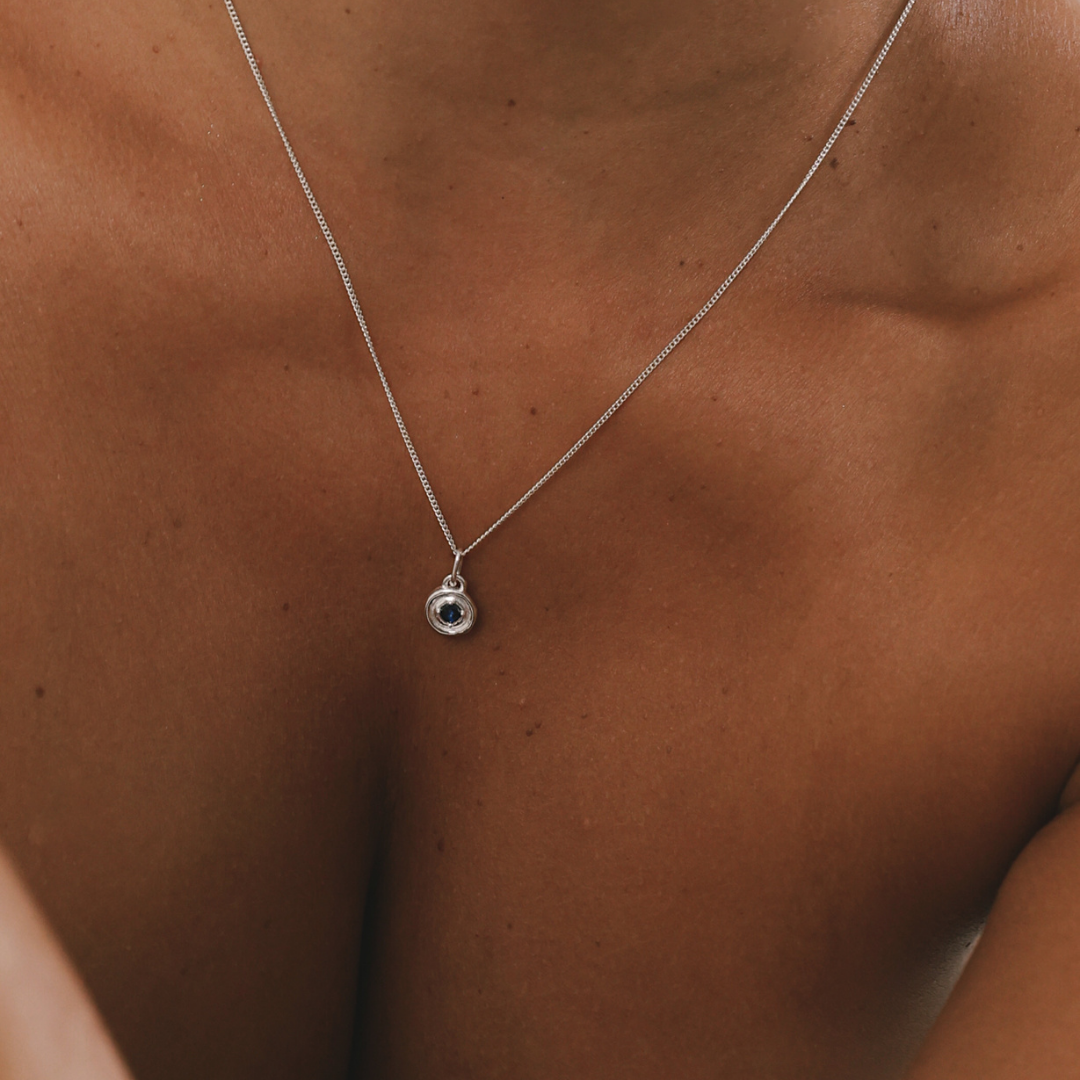 Silver necklace with a pendant on a person's chest