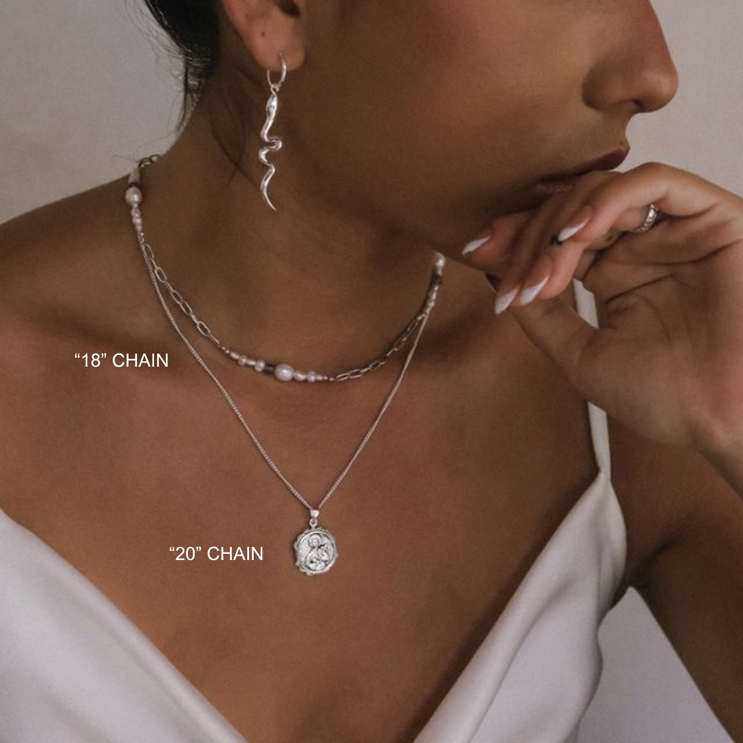 Woman wearing a silver necklace with a pendant, with text indicating chain lengths.