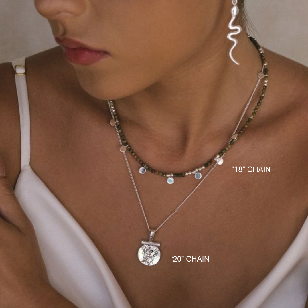 Close-up of a woman wearing layered necklaces with chain lengths labeled.