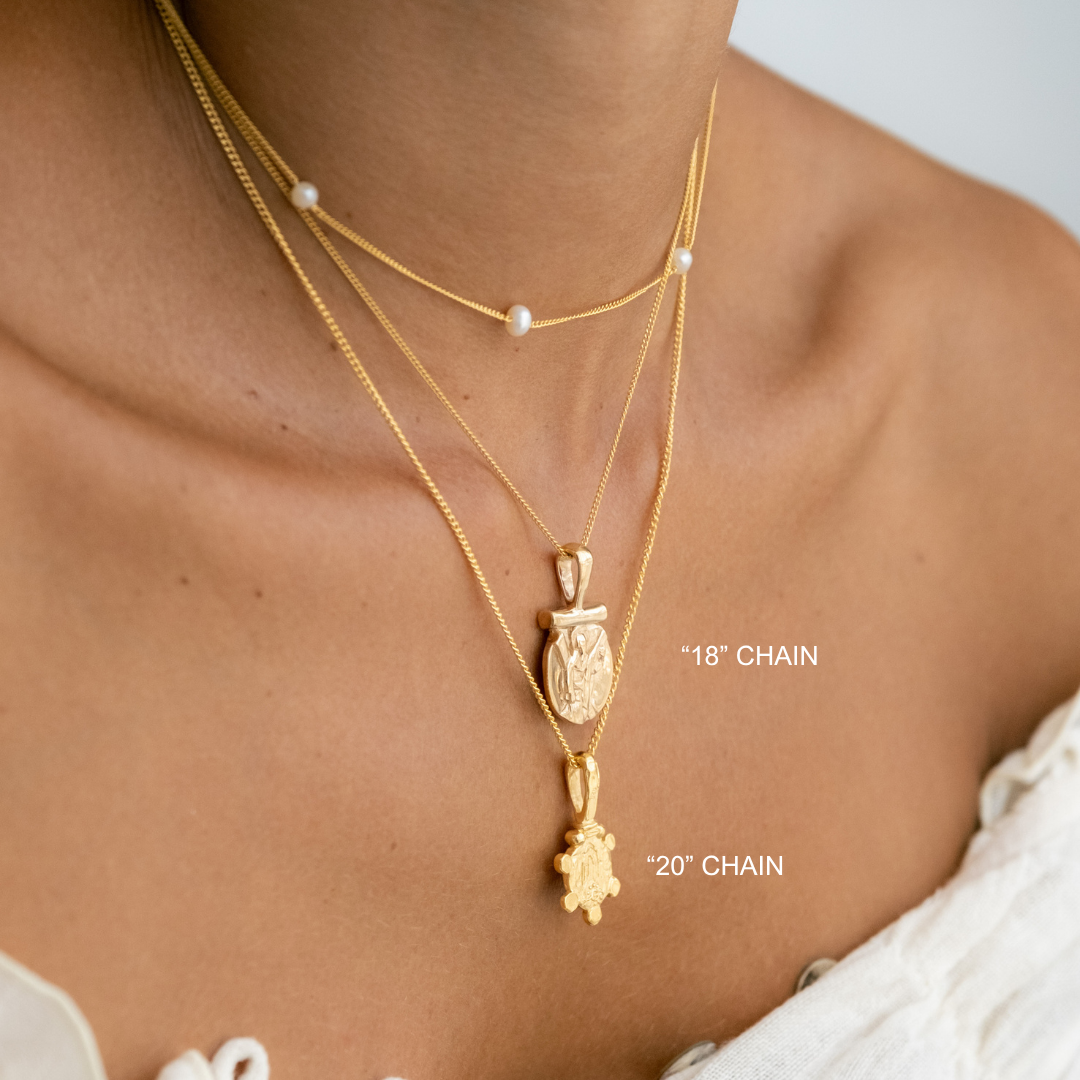 Gold necklaces with pendants on a person's neck, labeled '18' chain' and '20' chain'.