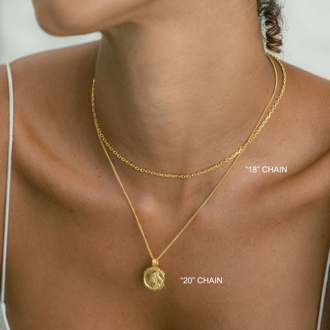Gold necklace with chain length labels on a person wearing a white top.