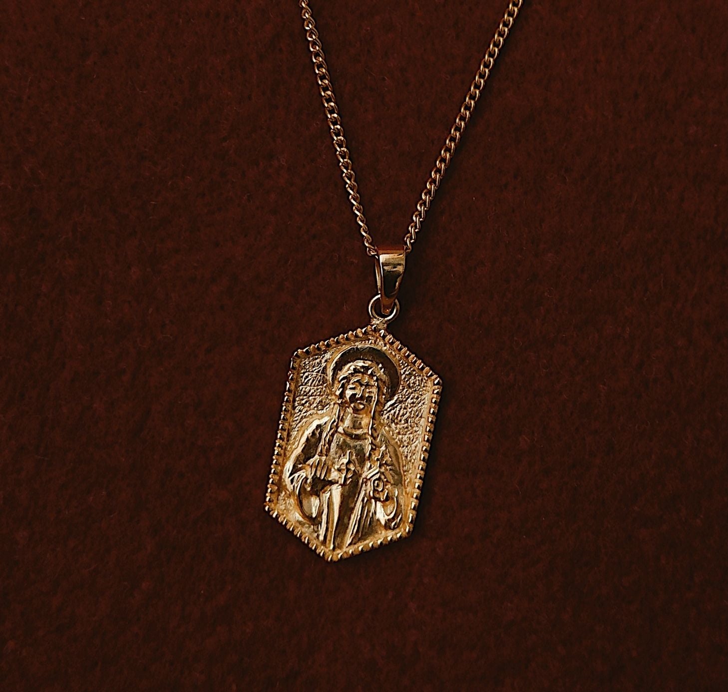 St Dwynwen - Saint of Love pendant gold flat lay in red fabric