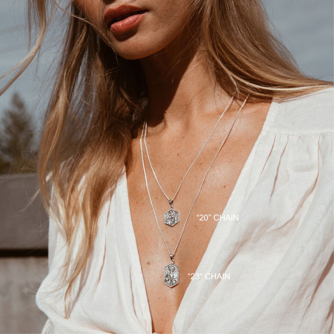 Close-up of a person wearing two necklaces with visible chain lengths.