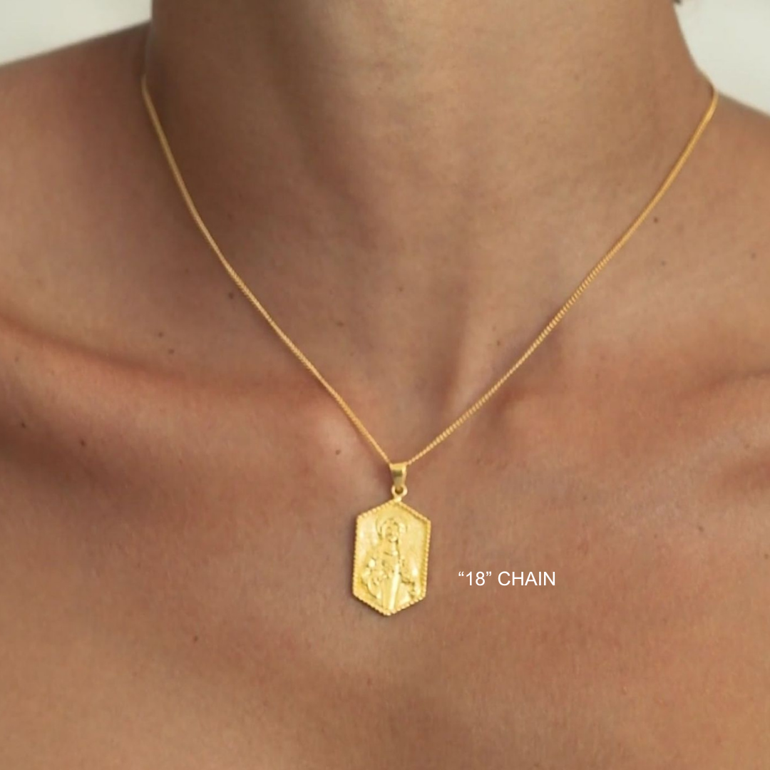Gold necklace with a pendant on a person's neck, labeled '18” chain'.
