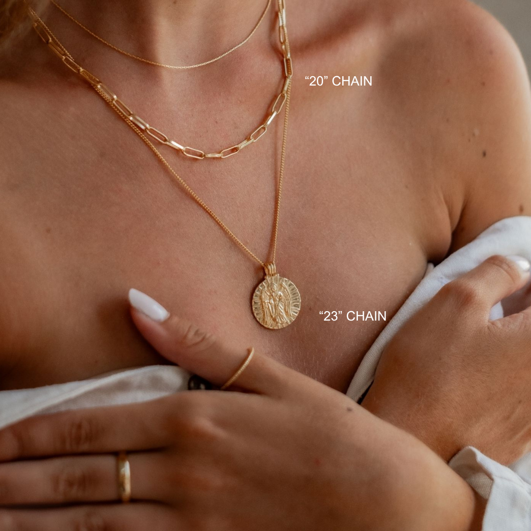 Gold chain necklaces with visible chain lengths on a person's neck.