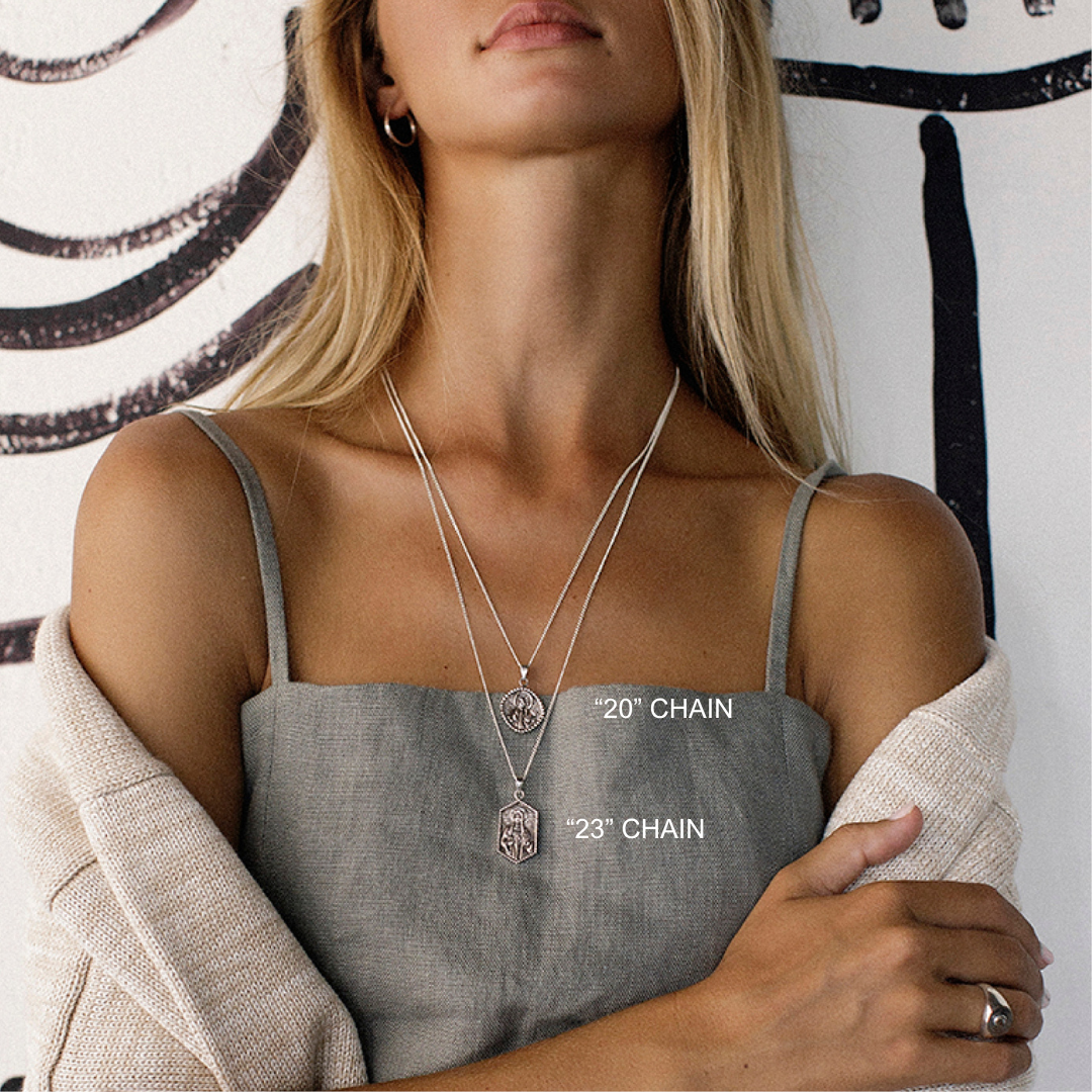 Woman wearing two necklaces with chain lengths labeled, against a neutral background.