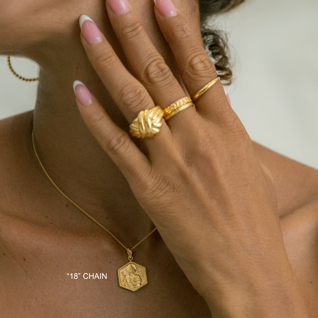 Close-up of a hand wearing gold jewelry with a blurred background