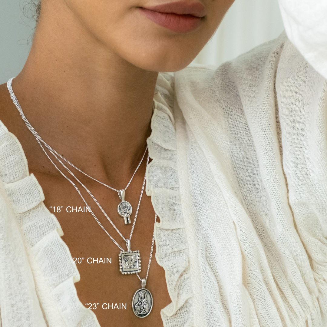 Close-up of a person wearing multiple silver necklaces with chain lengths labeled.