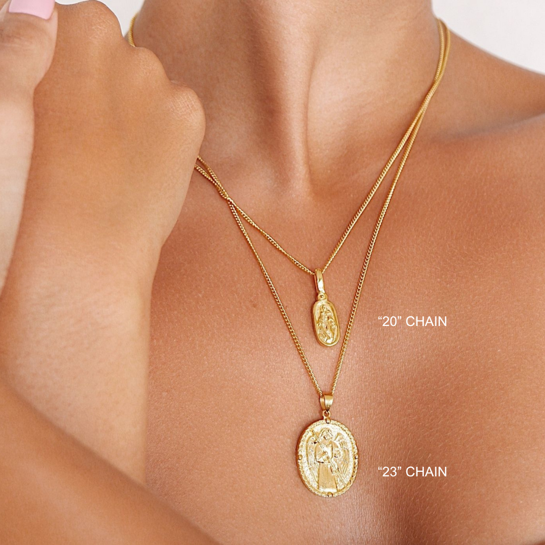 Gold necklaces with pendants on a person's neck, showing chain lengths.