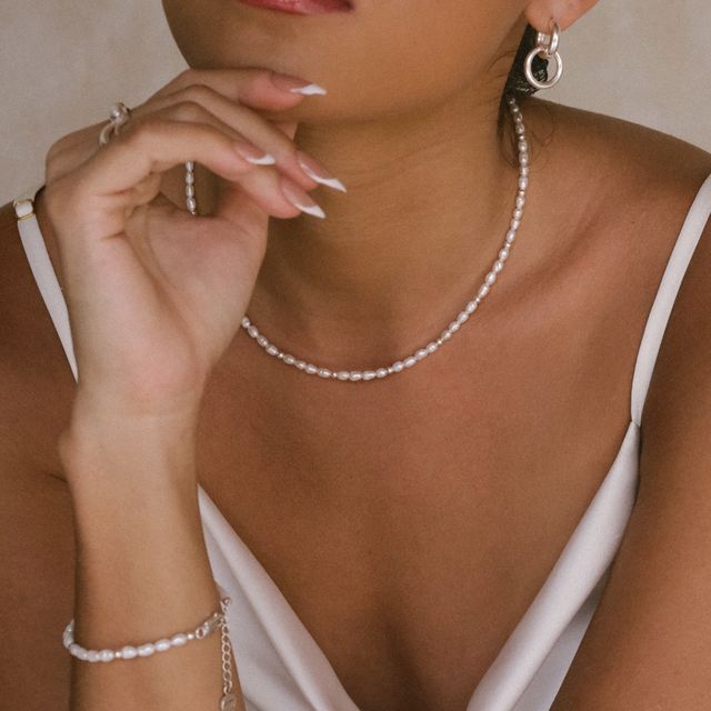 Stylish woman accessorized with a full set of silver jewelry