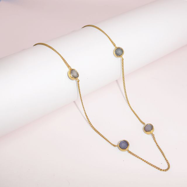 The Noa Necklace - Gold placed on a white roll