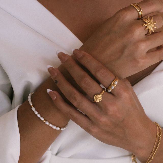  a woman with multiple jewelry on her hands
