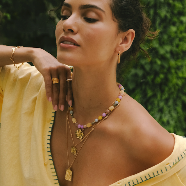 Woman in a yellow dress adorned with gold jewelry for a chic look by luna rose