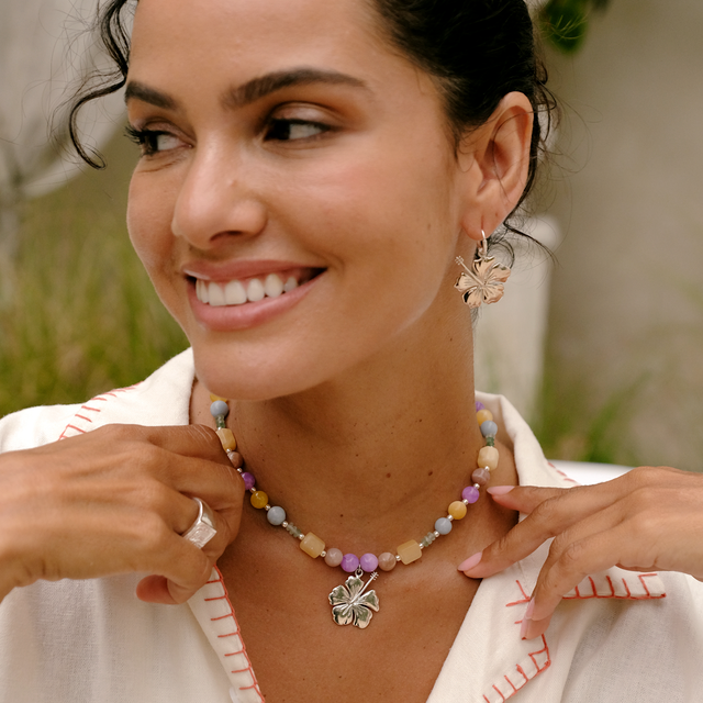 Woman styled in a white shirt with layered silver jewelry by luna rose