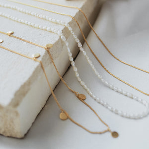 a multiple bracelets gold displayed on beige stone