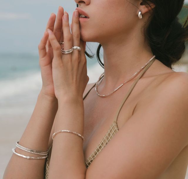 a woman in the beach wearing  jewelry silver