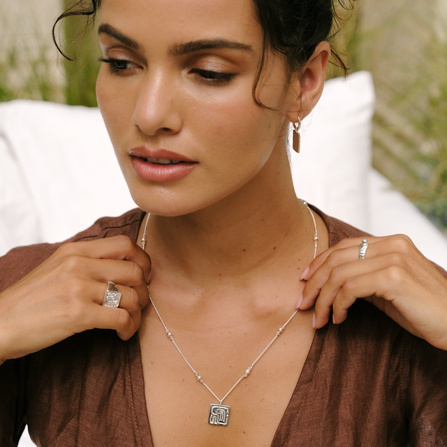 Elegant look: woman in a cocoa dress styled with silver jewelry