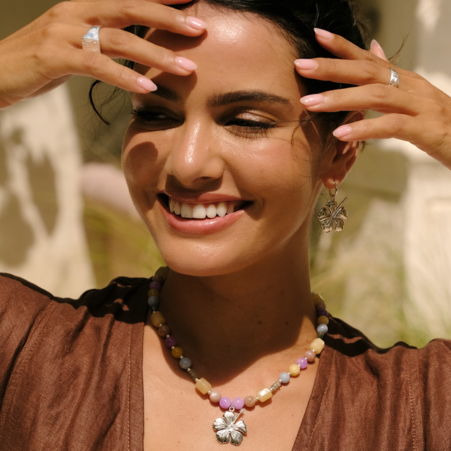 Lifestyle shot of a woman wearing a cocoa dress and silver gemstone necklace by luna rose