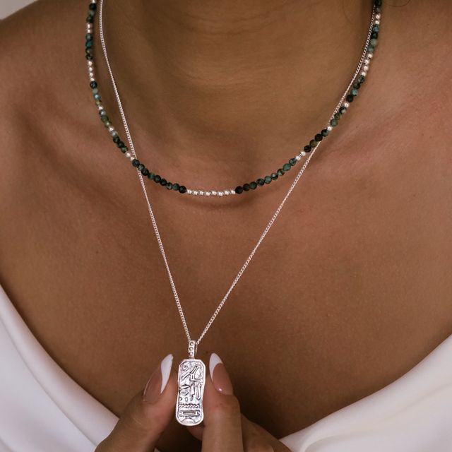 a woman with layered  silver necklaces 