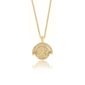 A gold necklace featuring a pendant with an intricate design and the words "SUN, EARTH, OCEAN HAPPINESS" inscribed on the top.