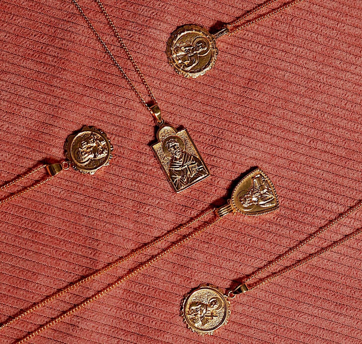 five necklaces gold flat lay in red fabric