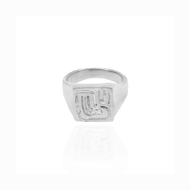 Close-up of a delicate silver ring on a bright white surface