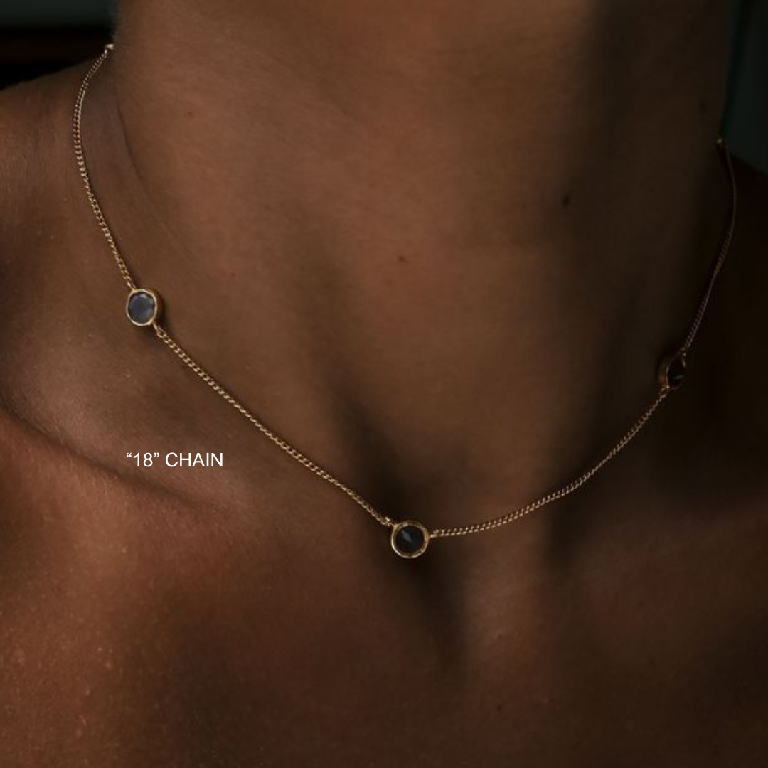 Necklace with small round pendants on a person's neck, labeled '18' chain'.