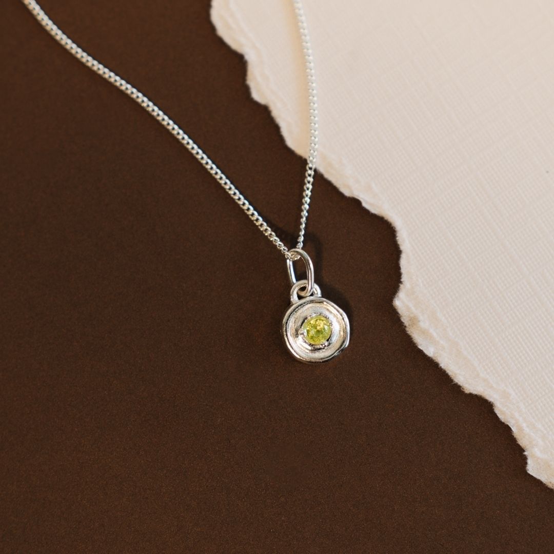 silver necklace featuring a fresh green peridot birthstone pendant with a polished finish