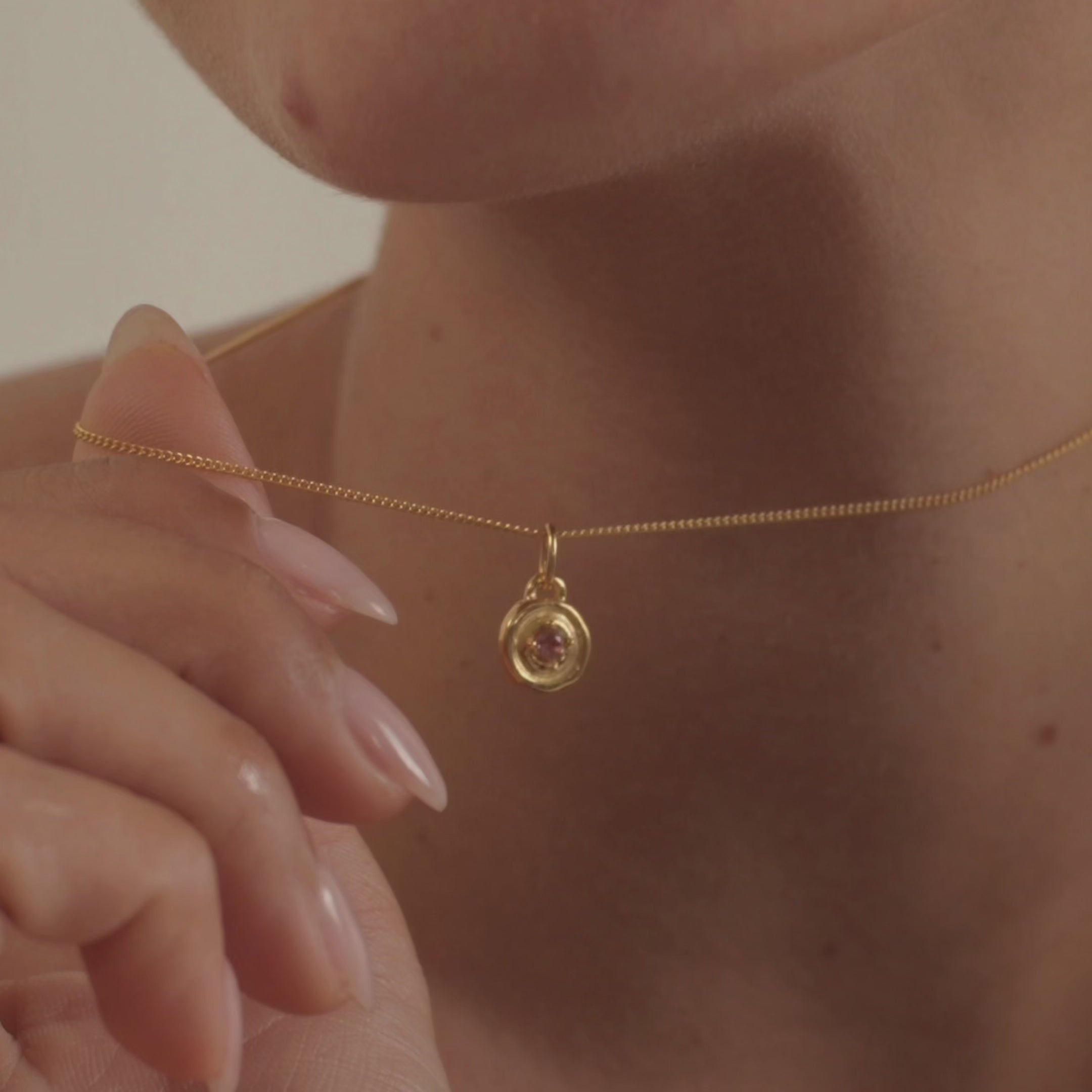 A model wearing an elegant pink tourmaline necklace, highlighting the gemstone's vibrant color and natural sparkle.