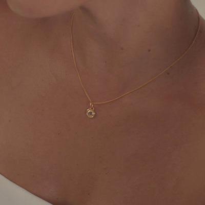 A model wearing an elegant amethyst birthstone necklace, highlighting the deep purple gemstone's natural sparkle.