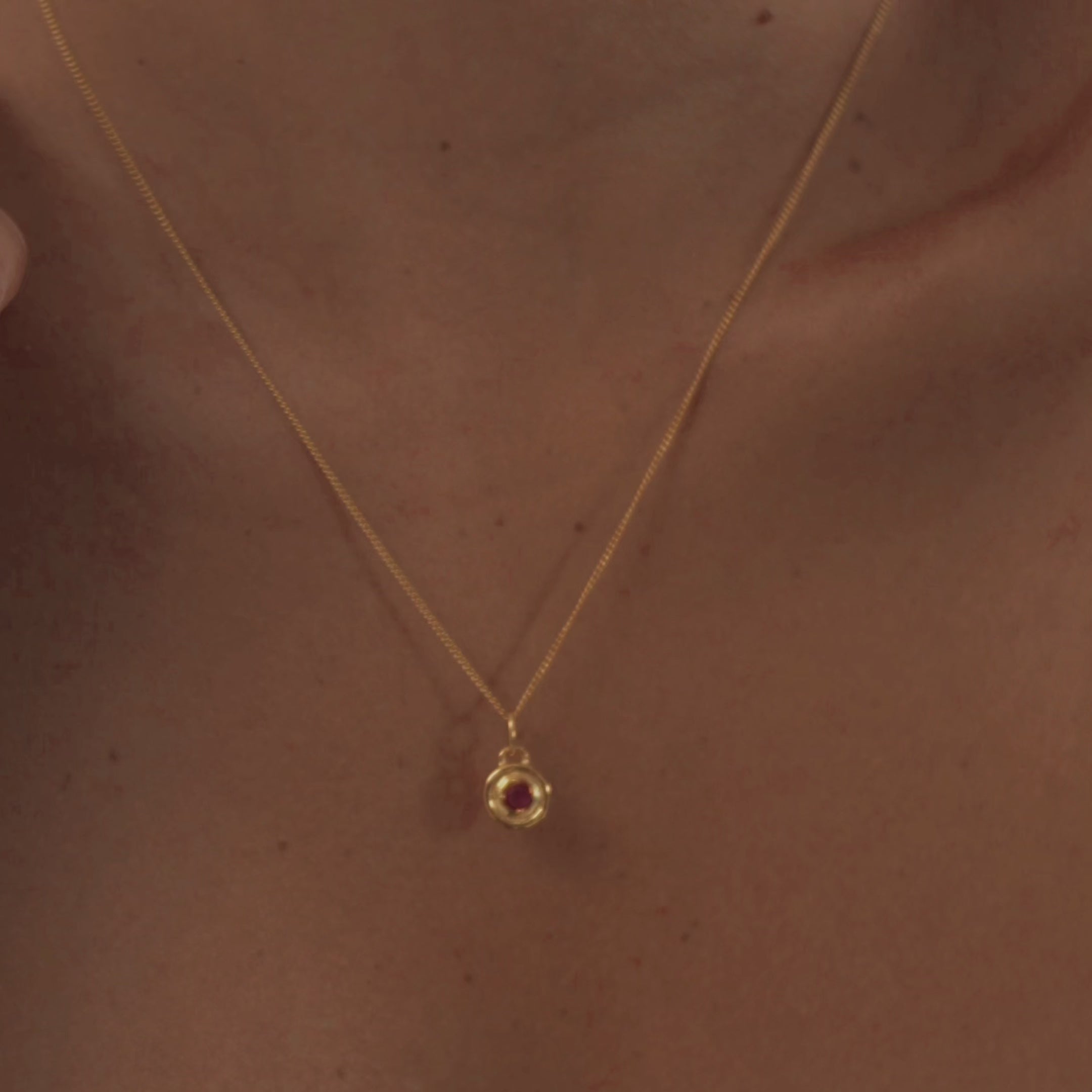 A model wearing a stunning garnet necklace, highlighting the rich red gemstone's deep color and natural warmth.