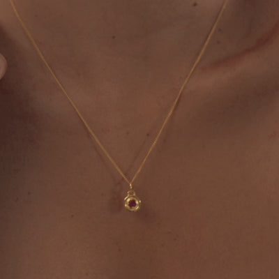 A model wearing a stunning garnet necklace, highlighting the rich red gemstone's deep color and natural warmth.