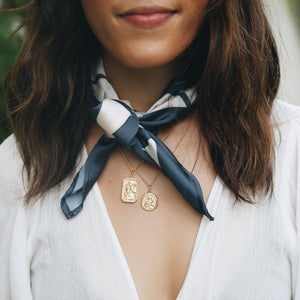 a woman with two pendants necklaces gold