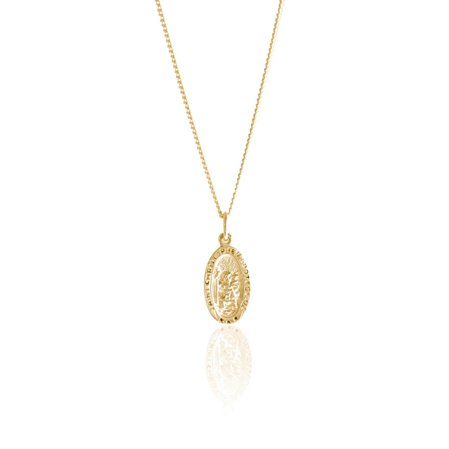 A gold necklace with an oval pendant featuring a raised religious figure design and the words "Saint Christopher Protect Us," displayed against a white satin fabric background.